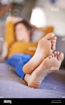 taking-it-easy-a-young-woman-lying-on-the-sofa-with-her-feet-crossed-2K2C6FC.jpg