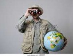 young-man-looking-through-binocular-and-holding-globe-again[...].jpg