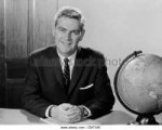 1960s-smiling-man-sitting-at-desk-with-earth-globe-looking-[...].jpg